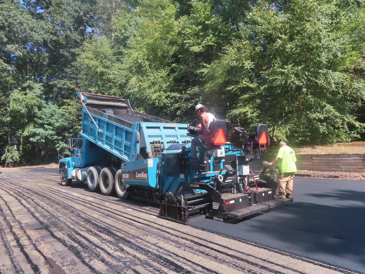 Commercial Parking Lot Paving project in Hamden, CT — dump truck feeding paver laying asphalt