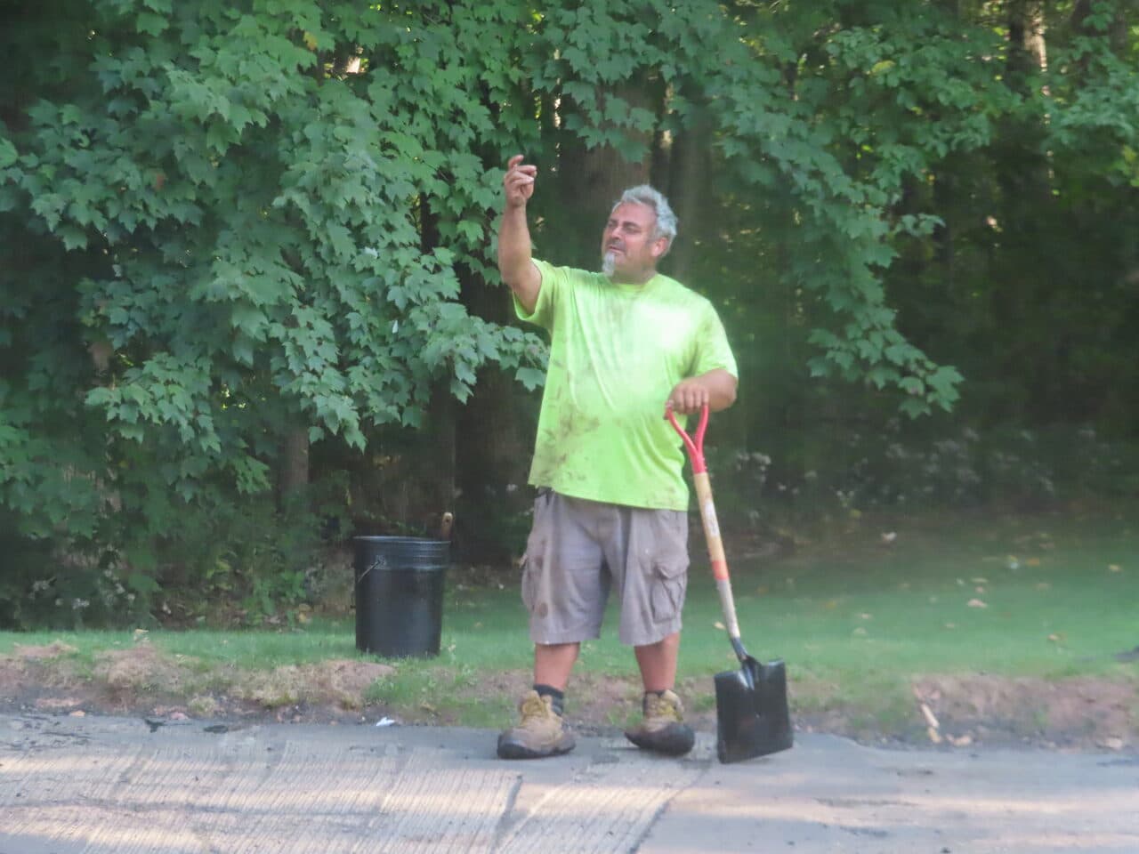 Commercial Parking Lot Paving project in Hamden, CT — worker with shovel pointing roadside