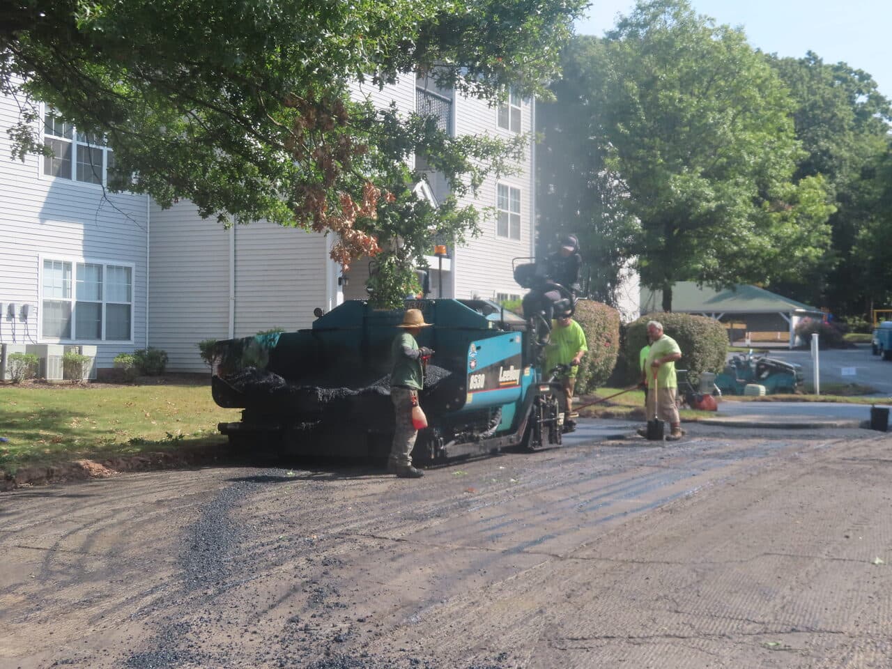 Commercial Parking Lot Paving project in Hamden, CT — paver laying asphalt by apartment building