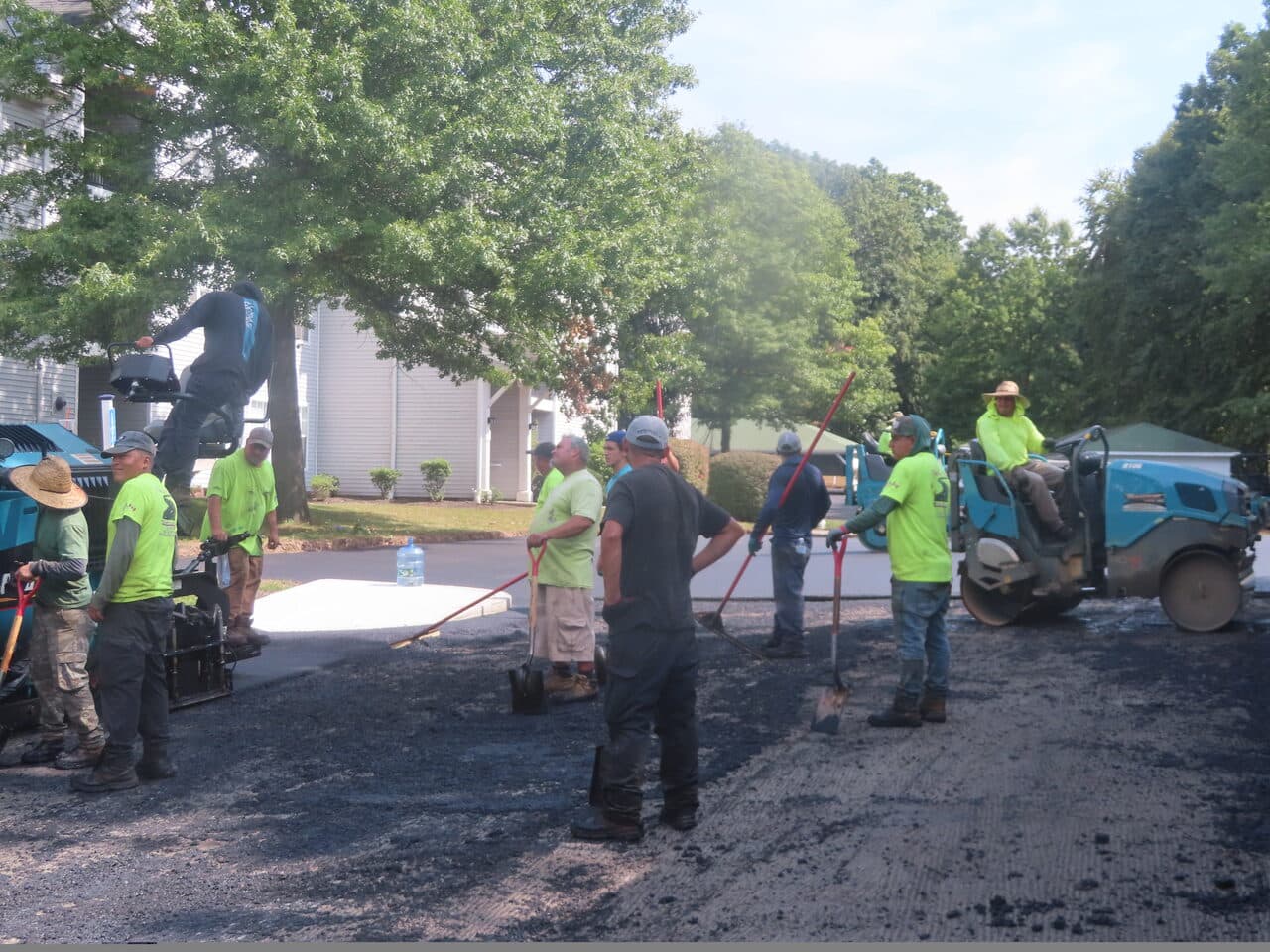 Commercial Parking Lot Paving project in Hamden, CT — crew with rakes around paver