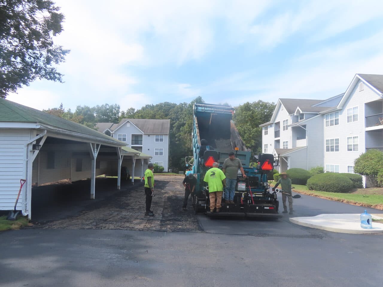 Before — Commercial Parking Lot Paving in Hamden, CT (paver laying asphalt by carport)