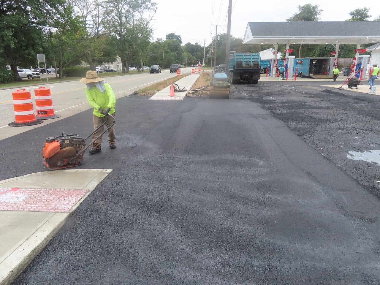 Commercial Parking Lot Paving project in Old Lyme, CT — compacting fresh asphalt near sidewalk