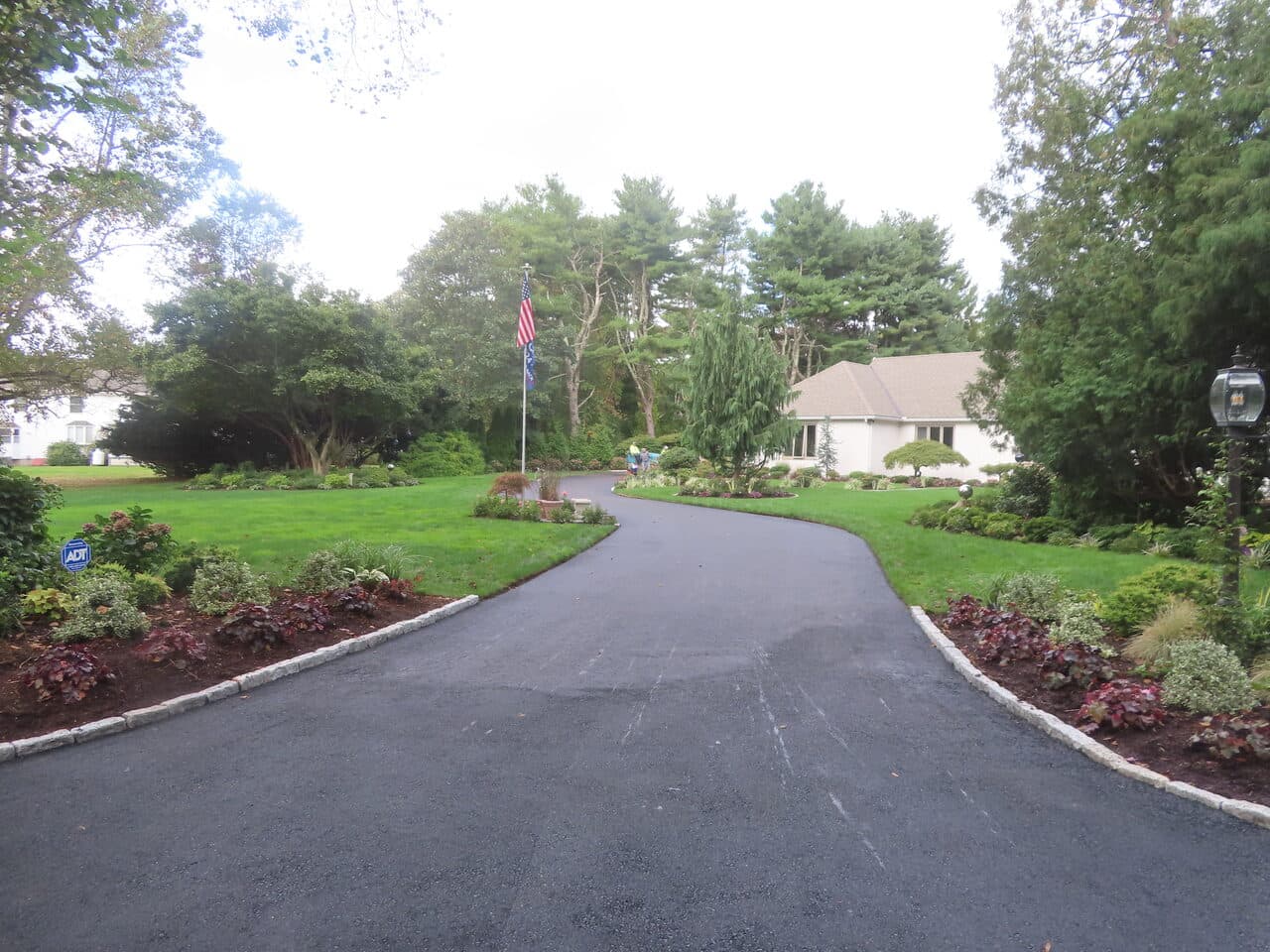 Residential Driveway Paving project in Branford, CT — finished asphalt driveway curving to house