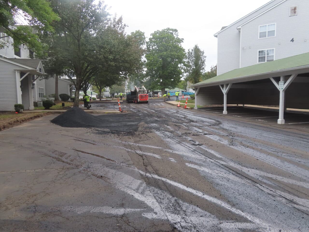 Commercial Parking Lot Paving project in Hamden, CT — paving in progress near carports
