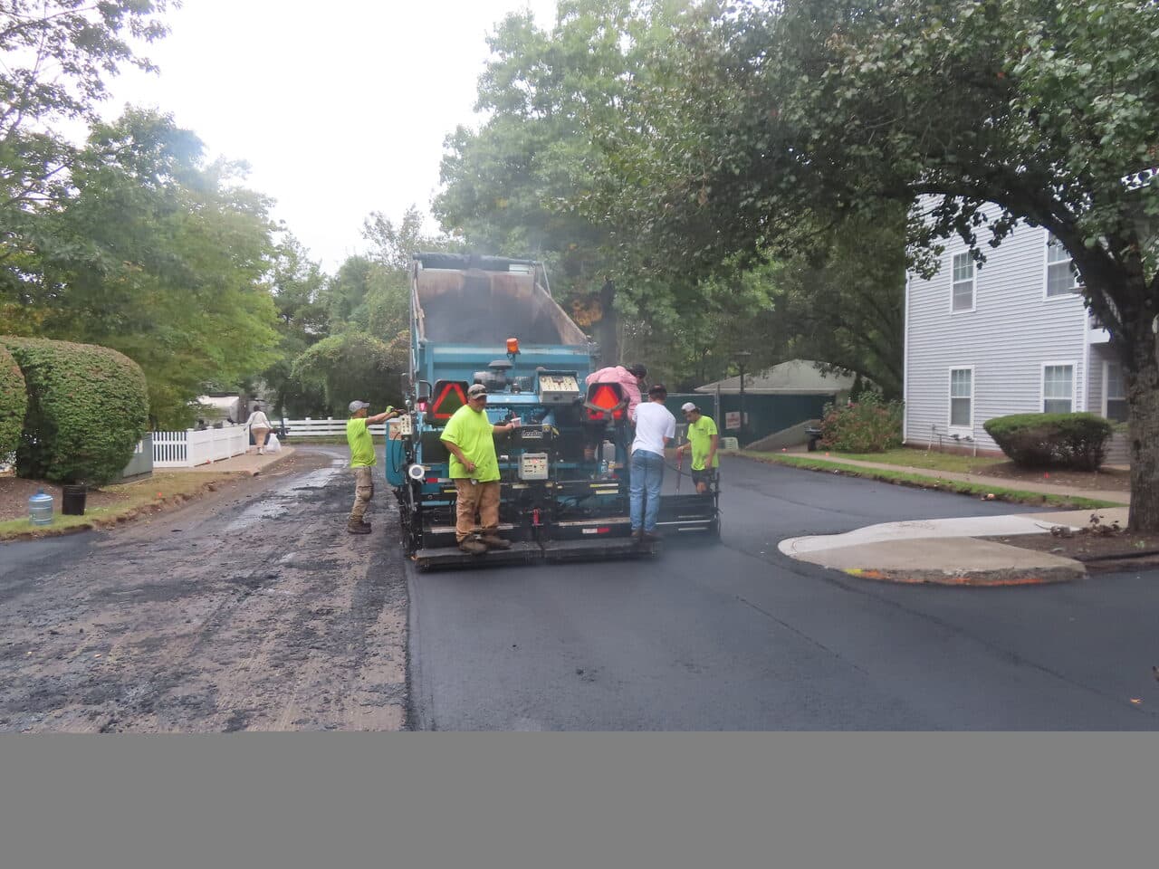 Commercial Parking Lot Paving project in Hamden, CT — paver laying asphalt with crew