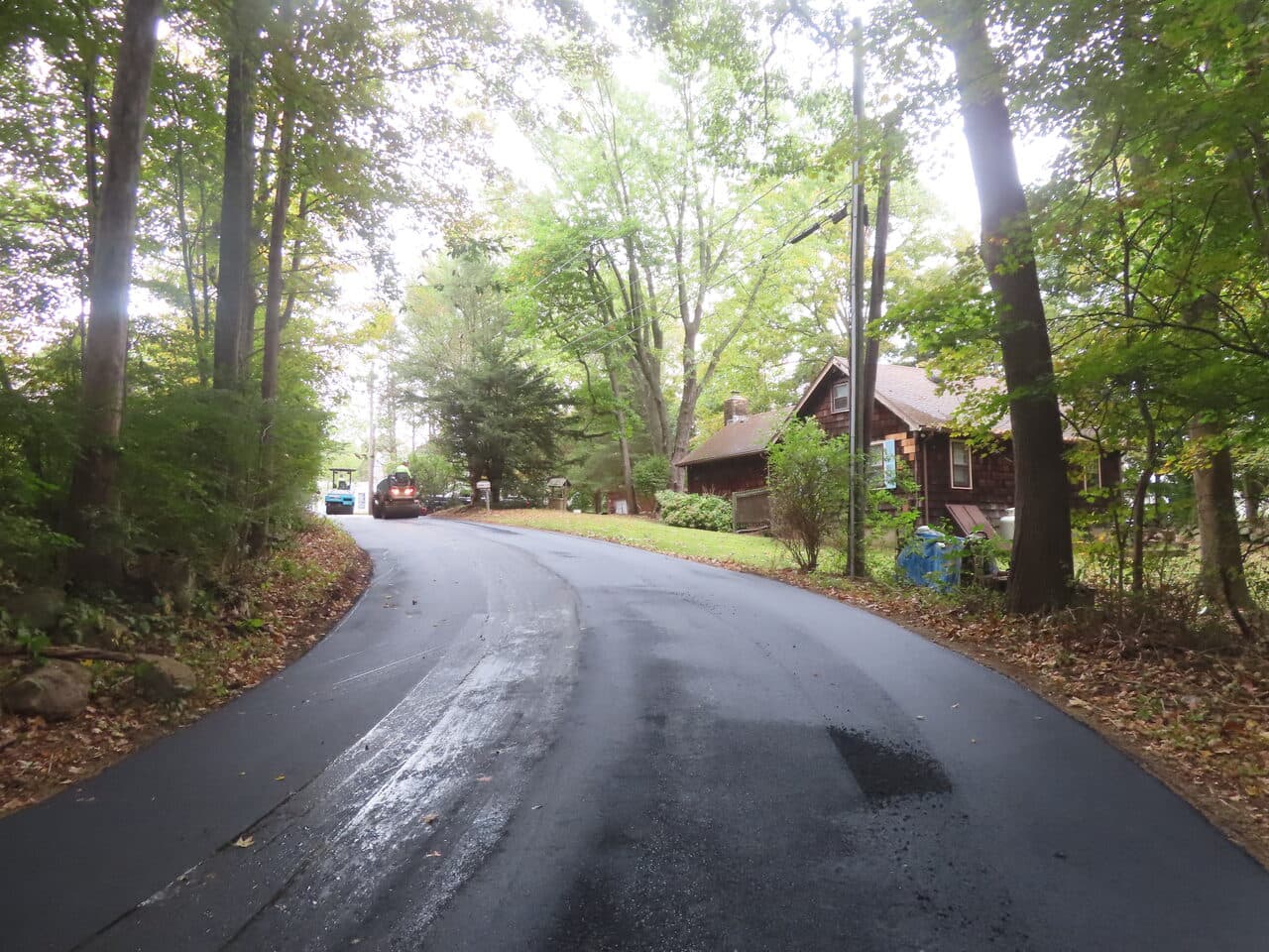 Roadway Paving project in Guilford, CT — finished asphalt road past house