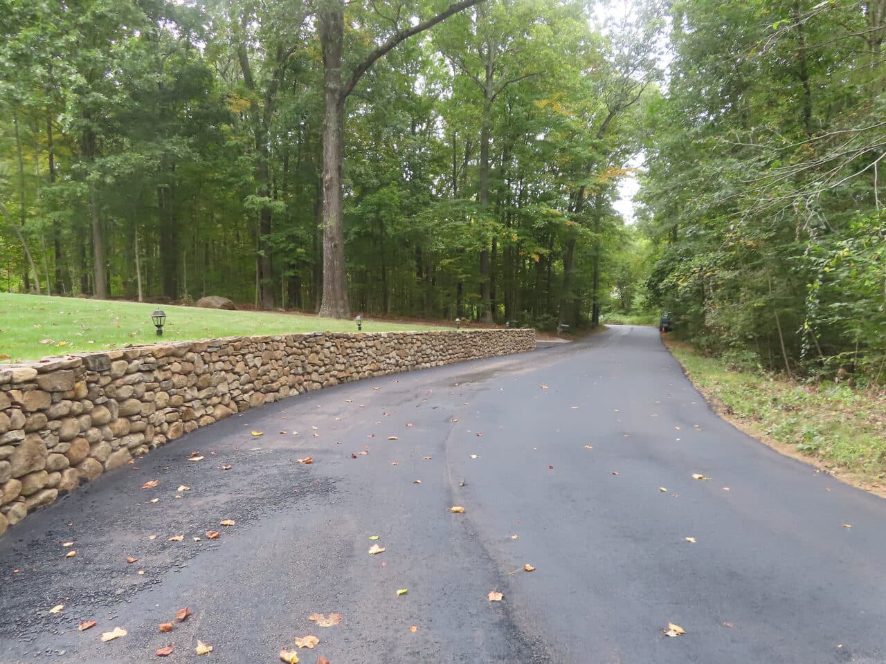 Roadway Paving project in Guilford, CT — finished asphalt drive by stone wall