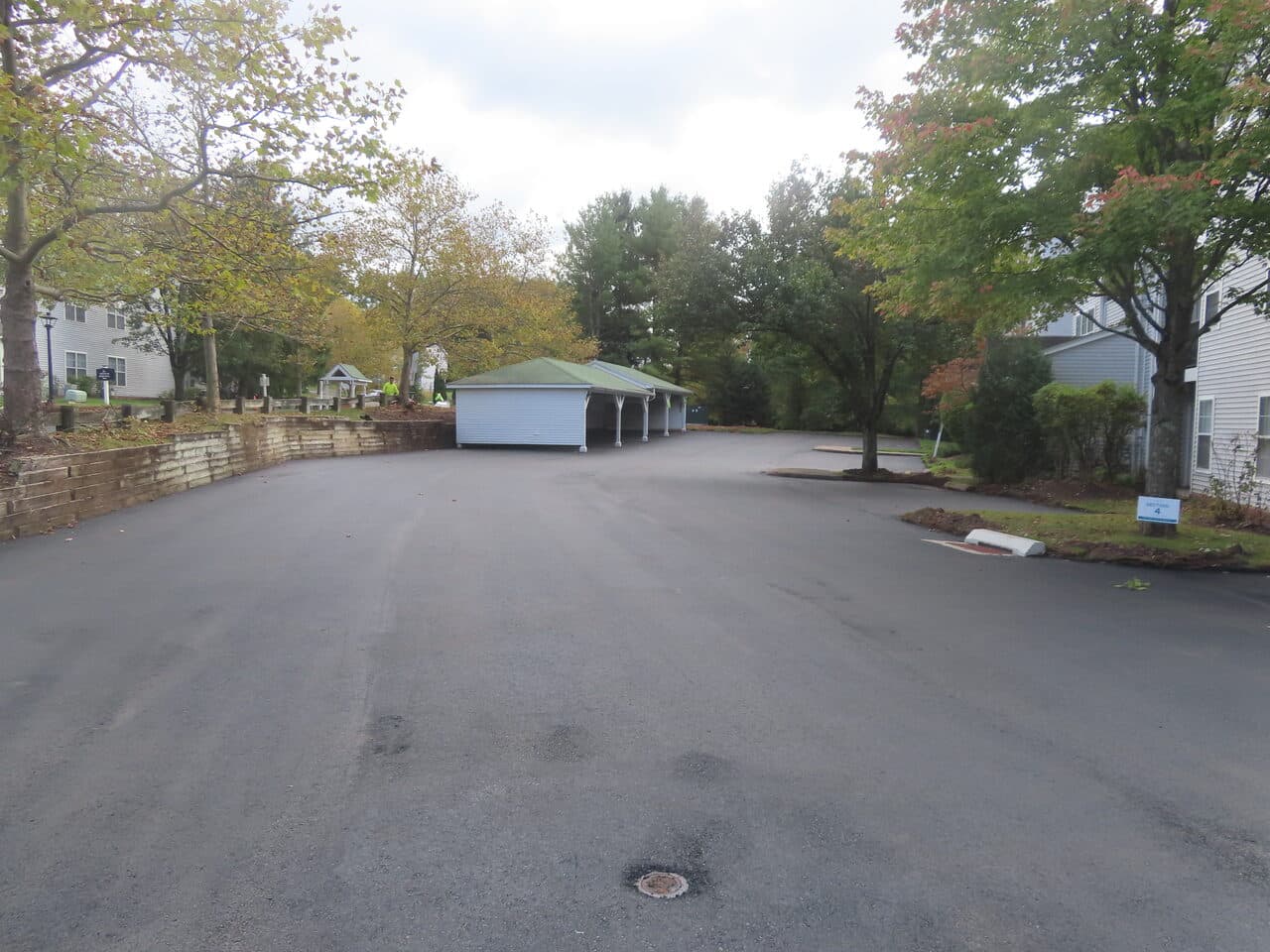 After — Commercial Parking Lot Paving in Hamden, CT (paver laying fresh asphalt by carport)