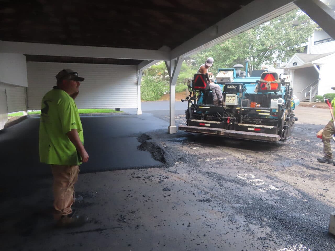 Commercial Parking Lot Paving project in Hamden, CT — paver laying asphalt under carport