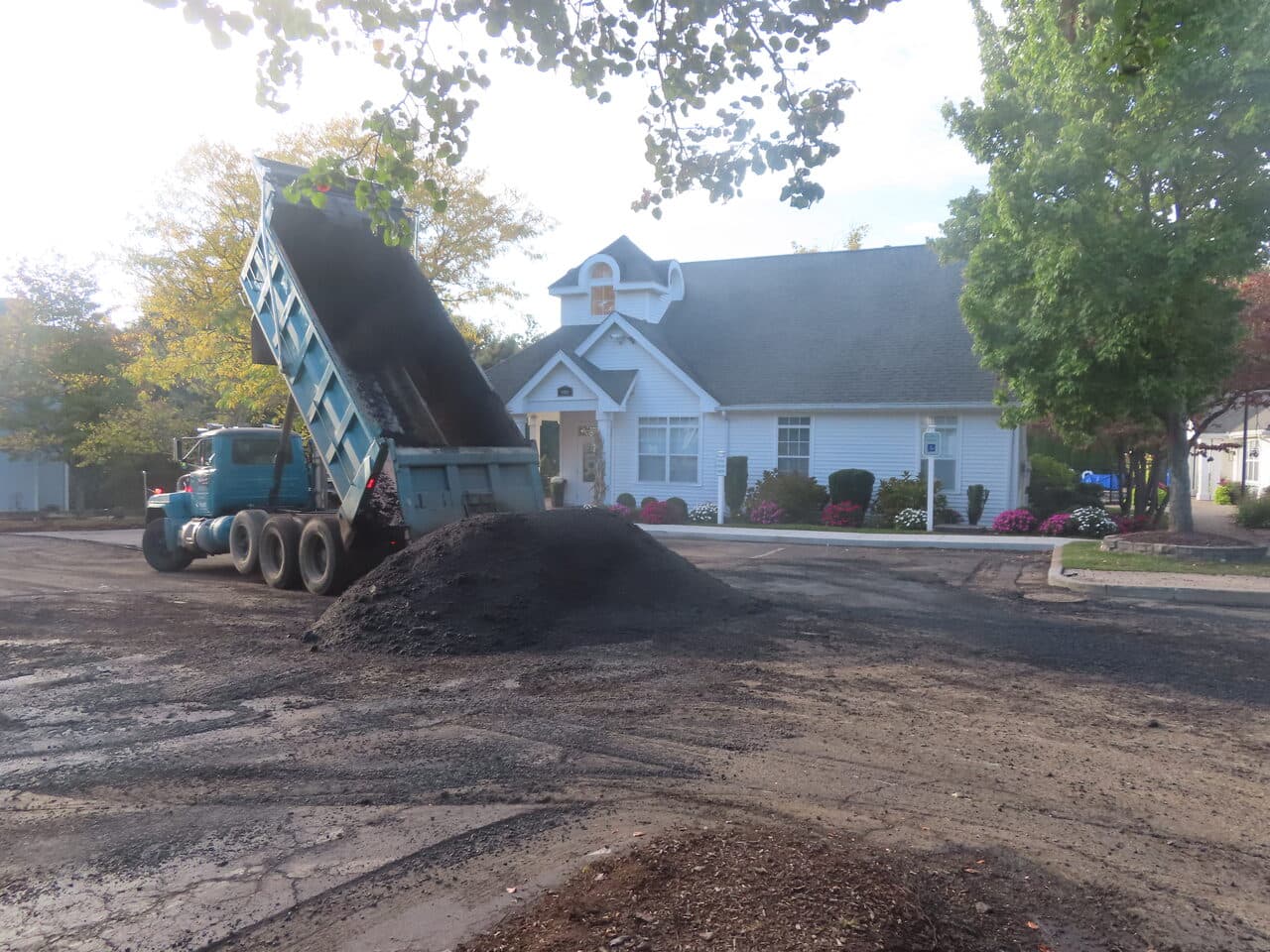 Commercial Parking Lot Paving project in Hamden, CT — dump truck dropping asphalt pile by clubhouse