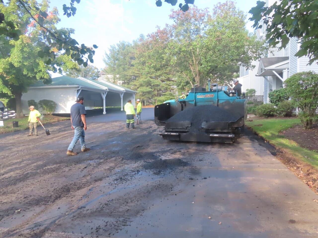 Before — Commercial Parking Lot Paving in Hamden, CT (paver laying fresh asphalt by carport)
