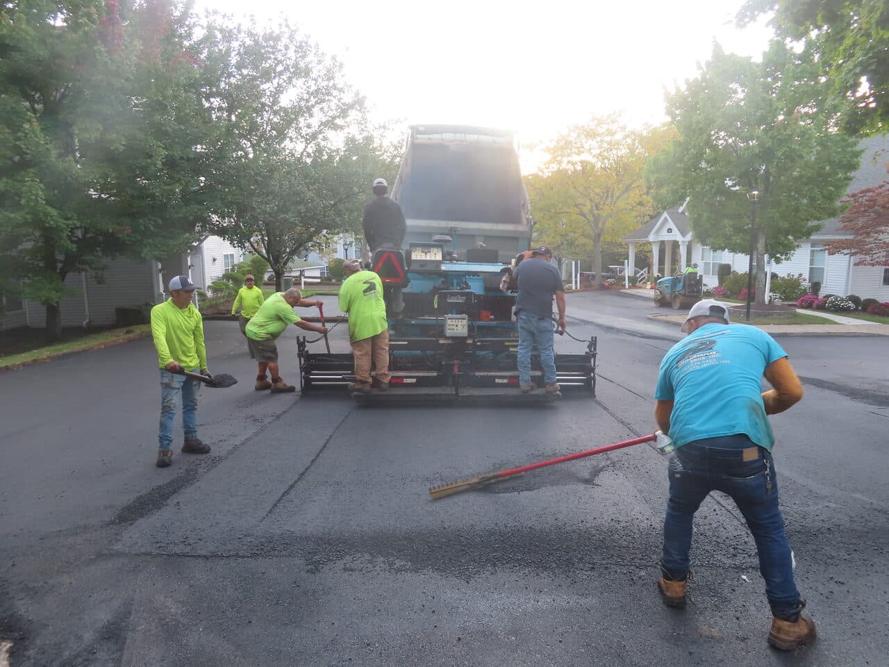 Commercial Parking Lot Paving project in Hamden, CT — crew raking behind paver on drive