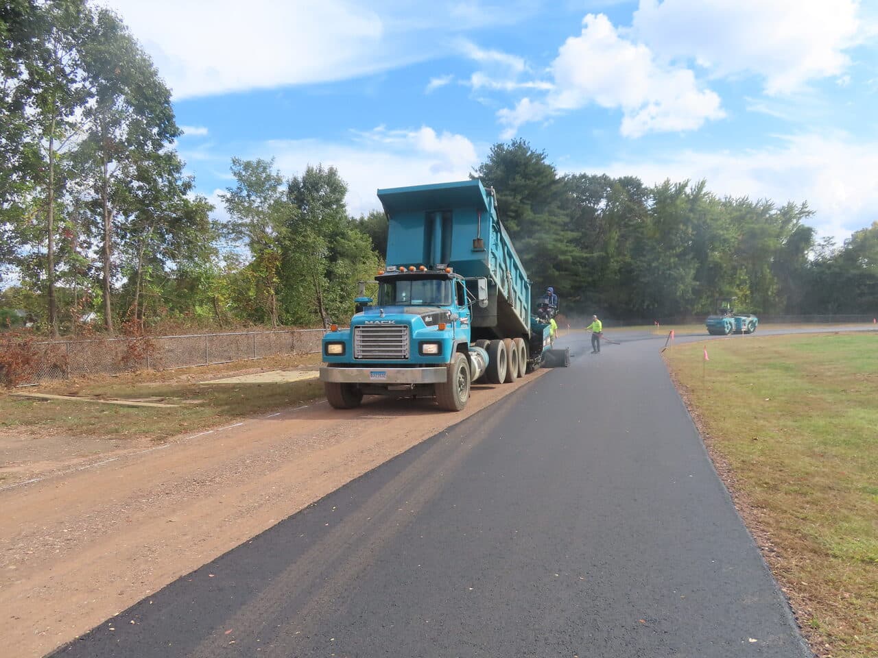 Athletic Surface Base Paving project in East Windsor, CT — dump truck on fresh access road
