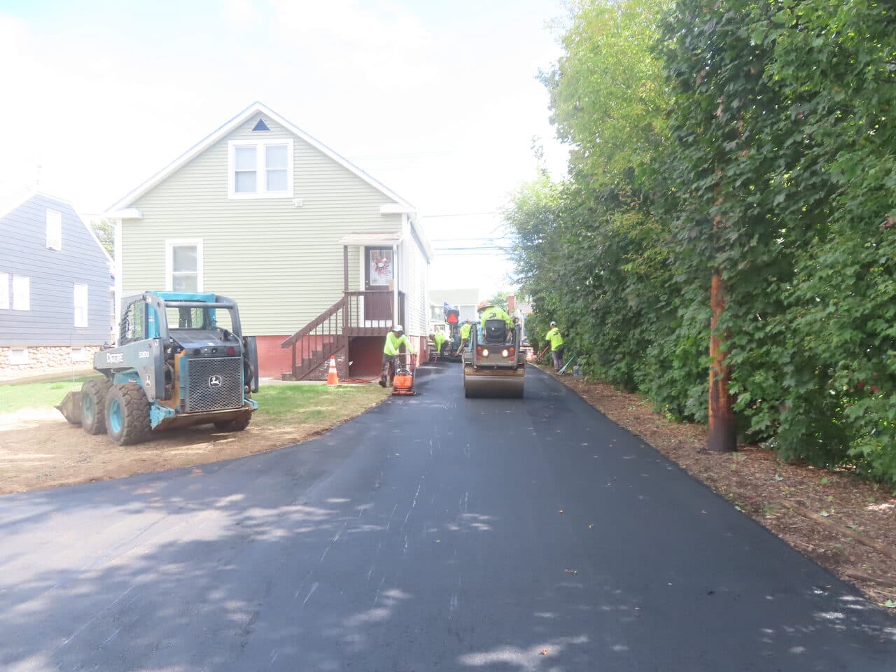 Commercial Parking Lot Paving project in East Haven, CT — fresh asphalt driveway beside green house