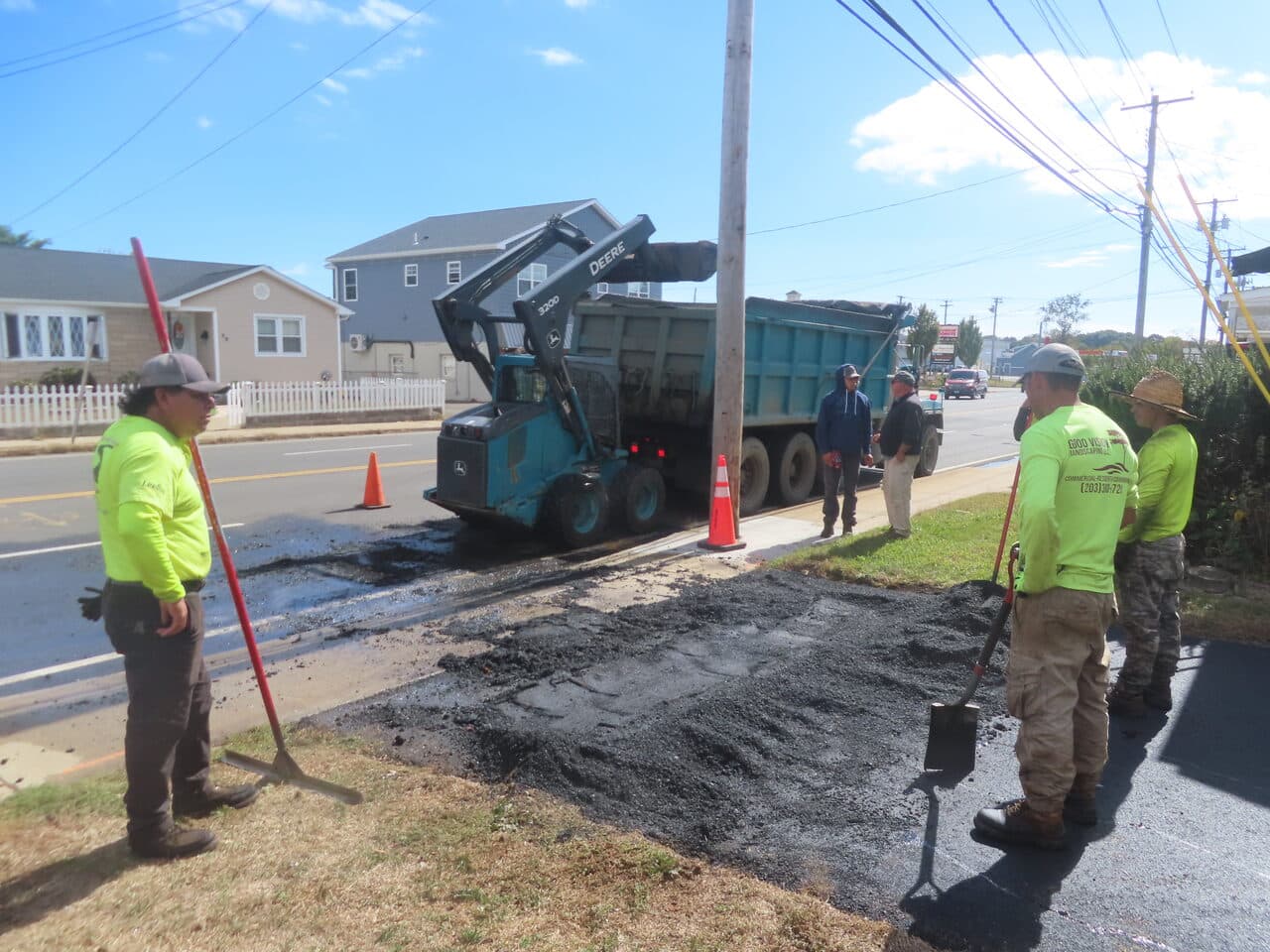 Commercial Parking Lot Paving project in East Haven, CT — skid steer dumping asphalt at street edge