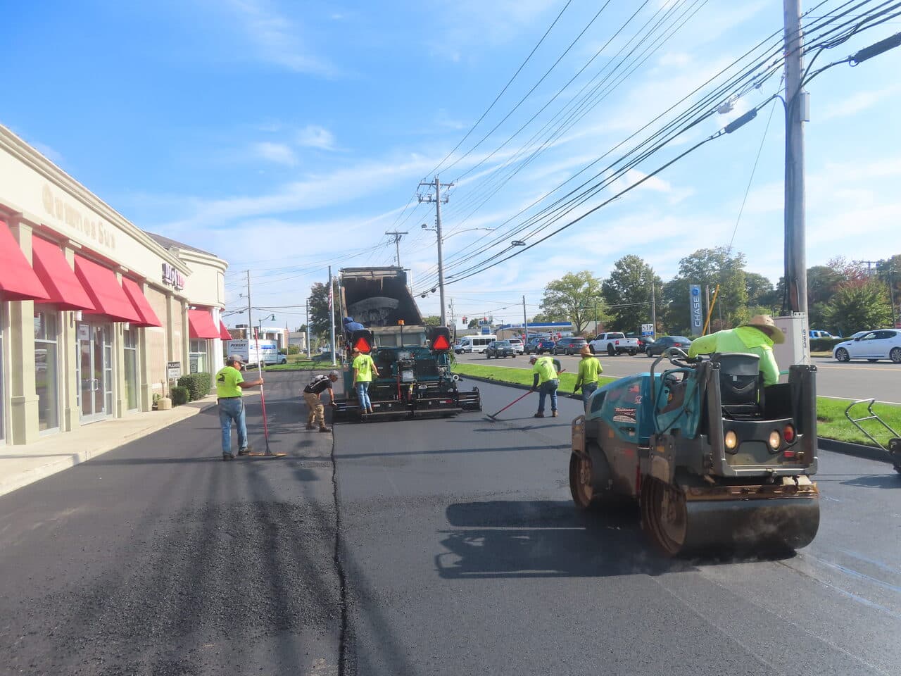 Commercial Parking Lot Paving project in Orange, CT — crew paving and rolling fresh asphalt