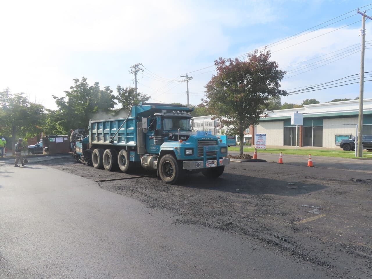 Commercial Parking Lot Paving project in Orange, CT — dump truck feeding paver on lot