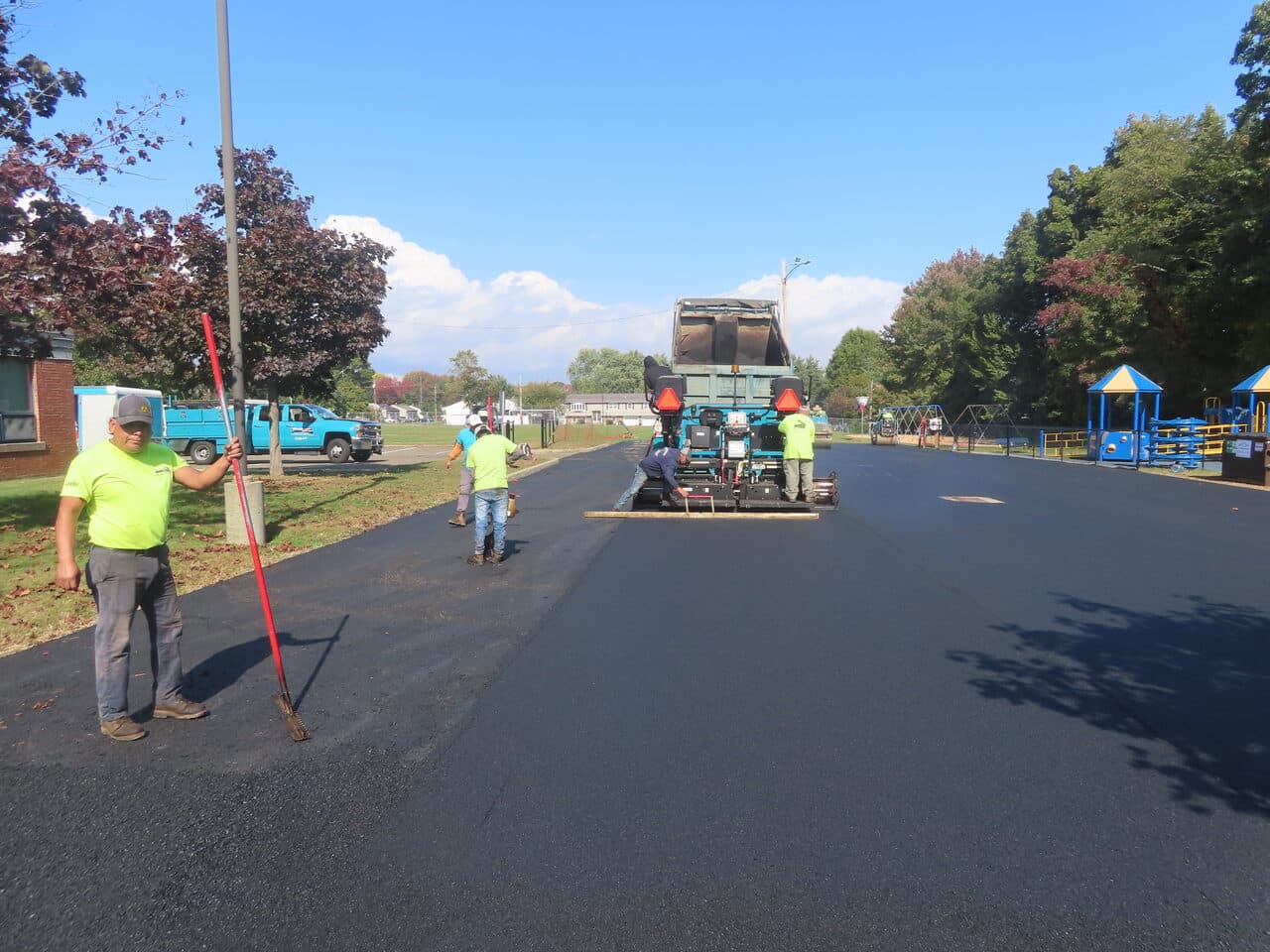 Commercial Parking Lot Paving project in West Haven, CT — paver laydown with worker holding rake
