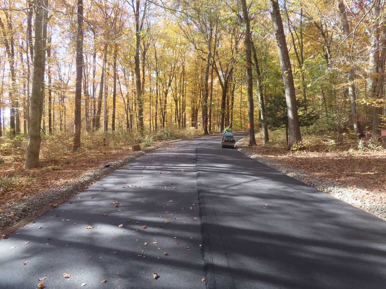 Roadway Paving project in Wallingford, CT — finished new asphalt road in woods