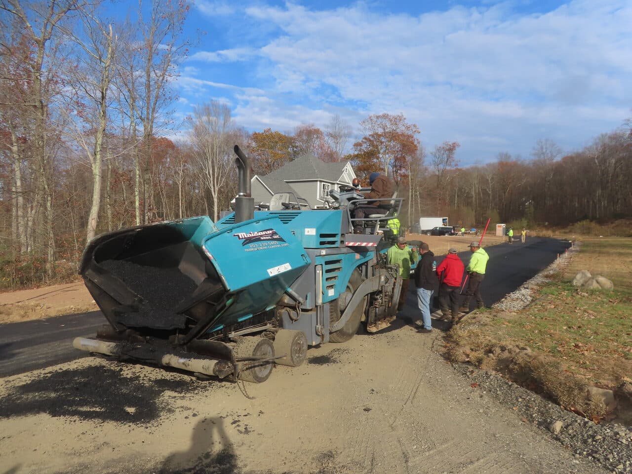 Roadway Paving project in Higganum, CT — paver laying asphalt near house