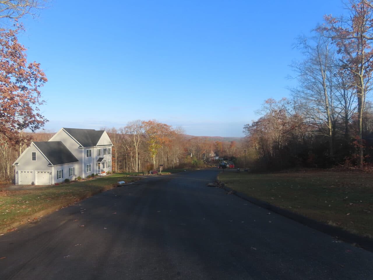 Roadway Paving project in Higganum, CT — fresh paved subdivision road by house