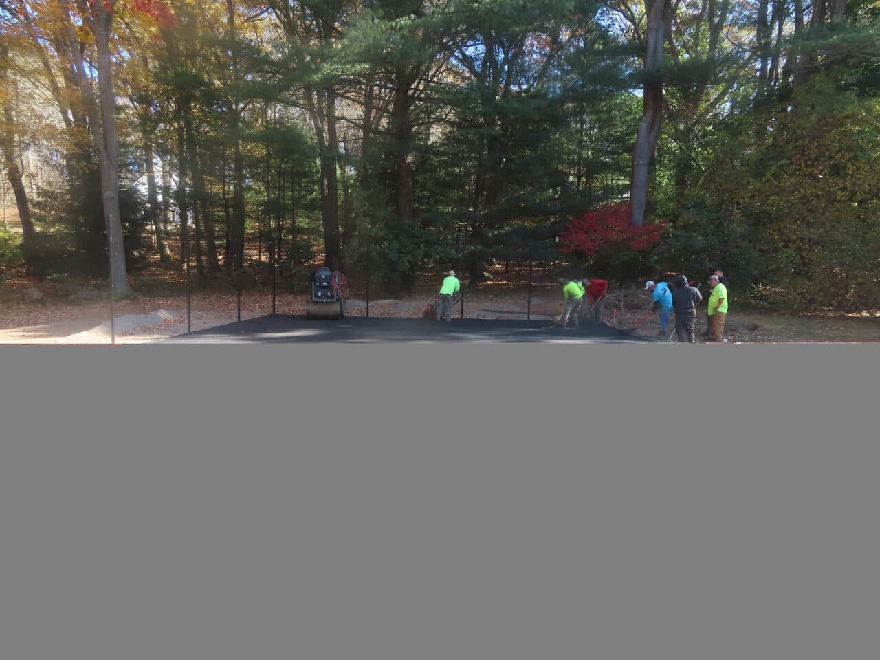 Residential Driveway Paving project in Stonington, CT — crew paving fresh asphalt at treeline