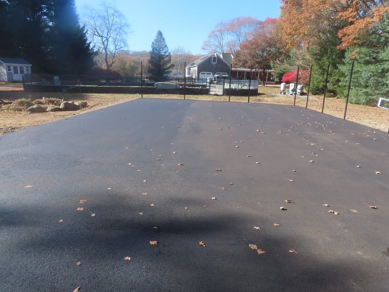 Residential Driveway Paving project in Stonington, CT — finished asphalt driveway by pool fence