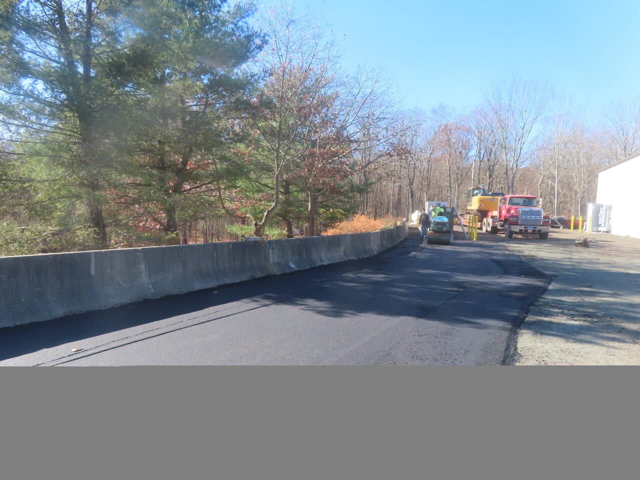Roadway Paving project in Northford, CT — finished paved lot along barrier wall