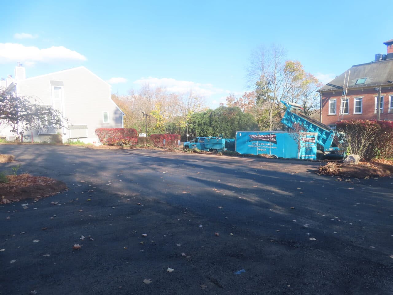 Commercial Parking Lot Paving project in Meriden, CT — wide finished lot with company trucks