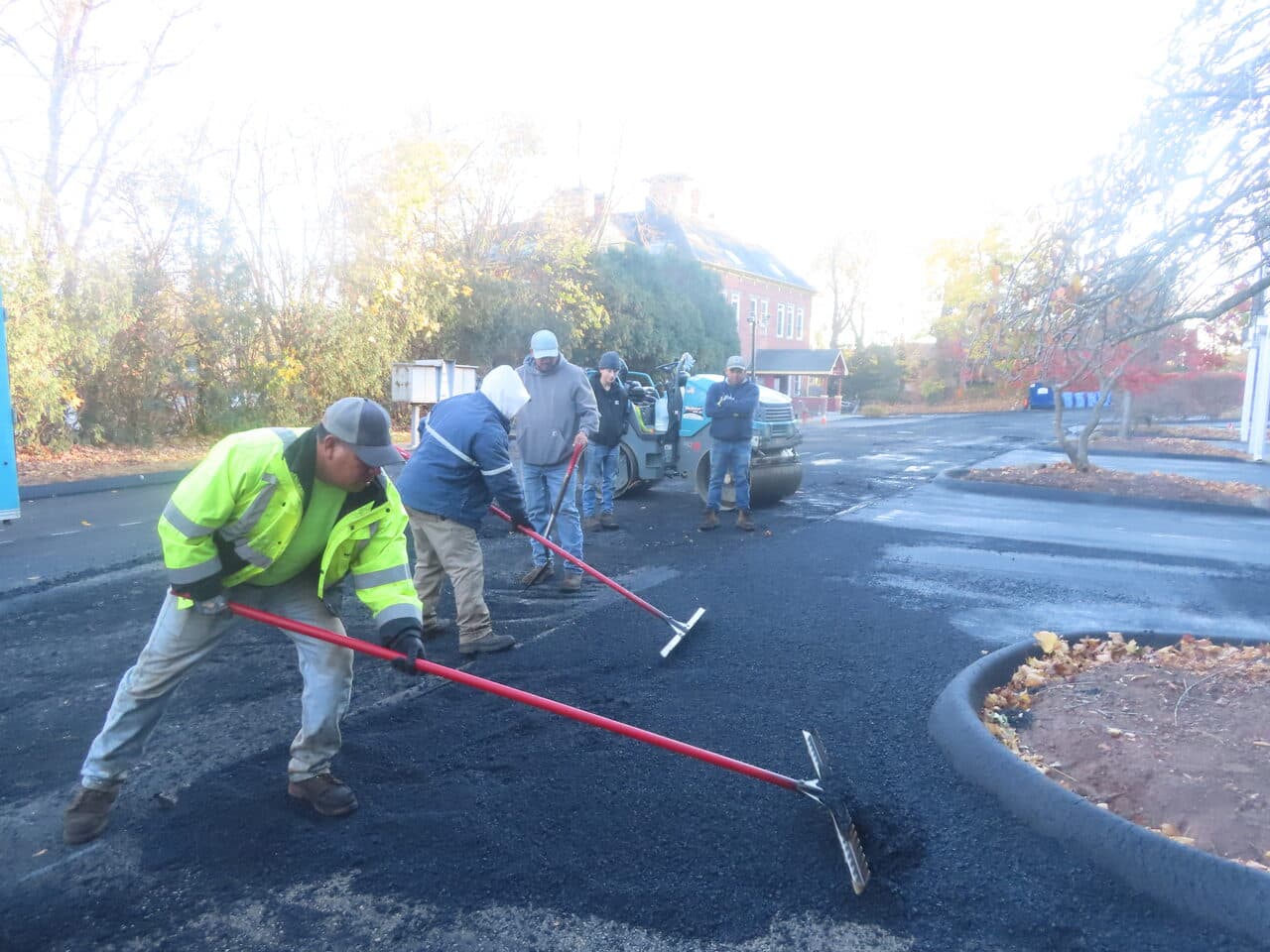 Commercial Parking Lot Paving project in Meriden, CT — crew raking fresh asphalt parking lot