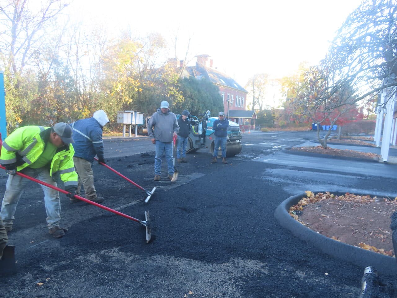 Commercial Parking Lot Paving project in Meriden, CT — crew raking asphalt near island