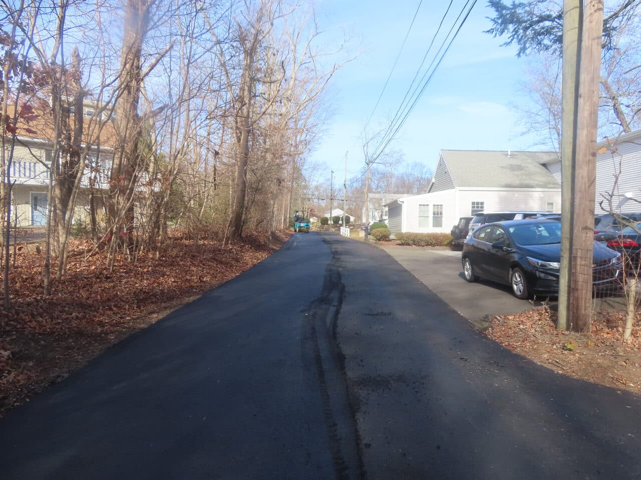 Roadway Paving project in Guilford, CT — finished asphalt lane between homes
