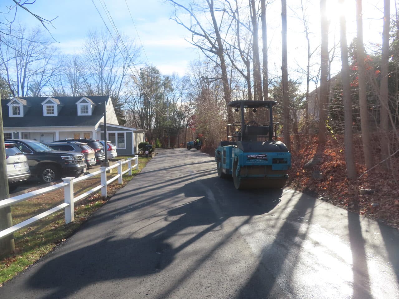Roadway Paving project in Guilford, CT — roller on new asphalt by homes