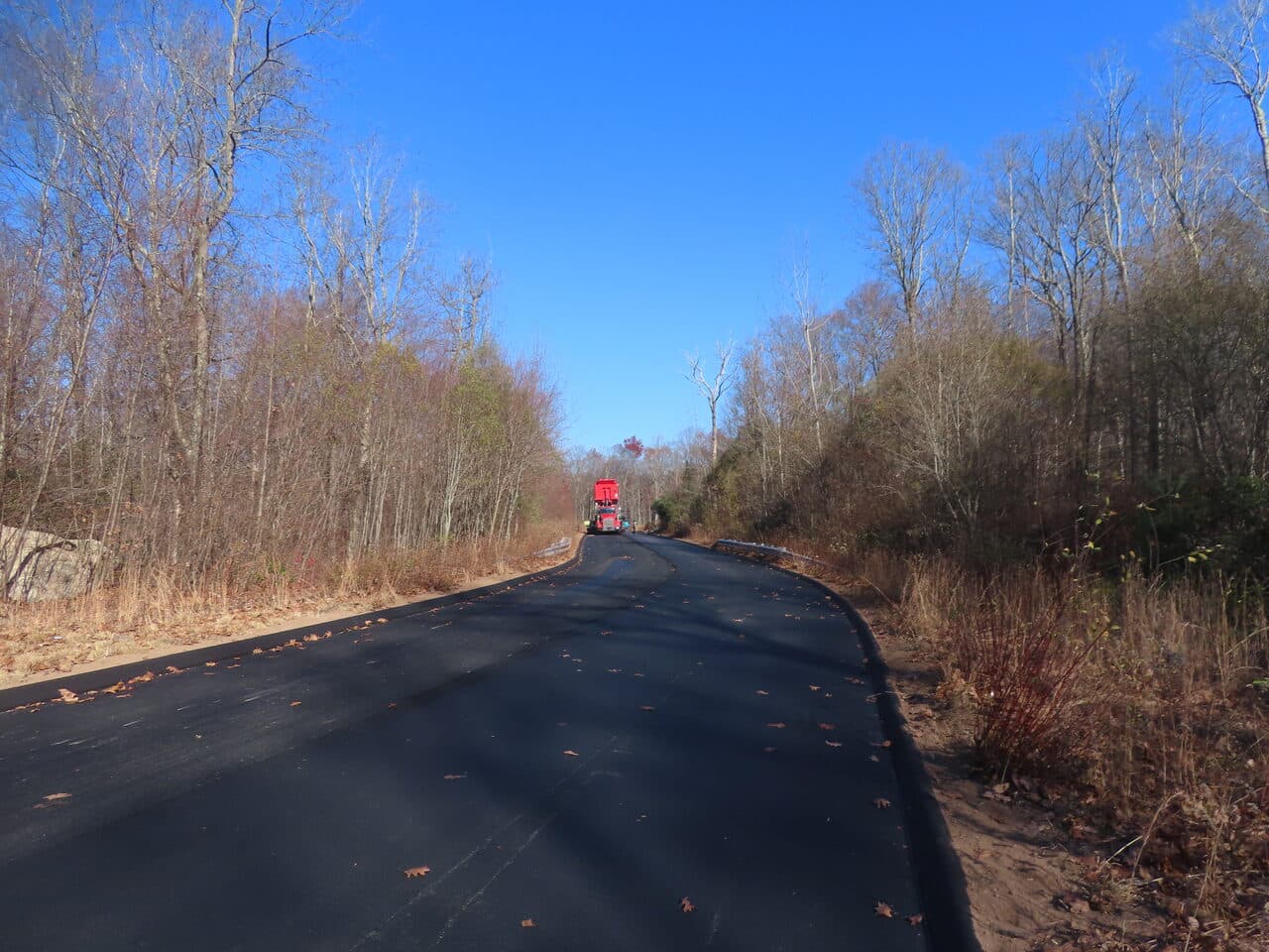 Roadway Paving project in Higganum, CT — fresh paved road through trees