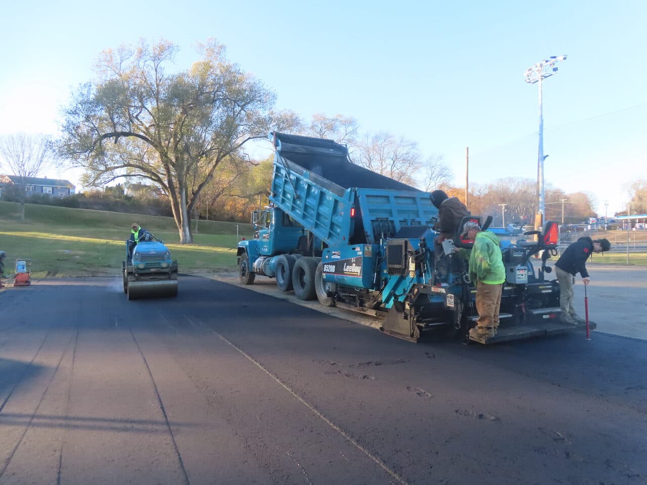 Commercial Parking Lot Paving project in Groton, CT — paver and roller laying fresh asphalt