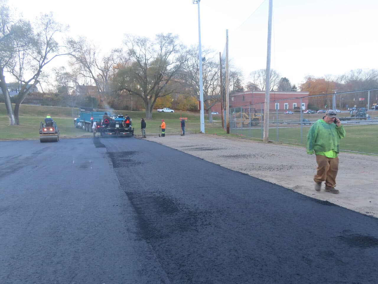 Commercial Parking Lot Paving project in Groton, CT — freshly paved lot with rollers and crew
