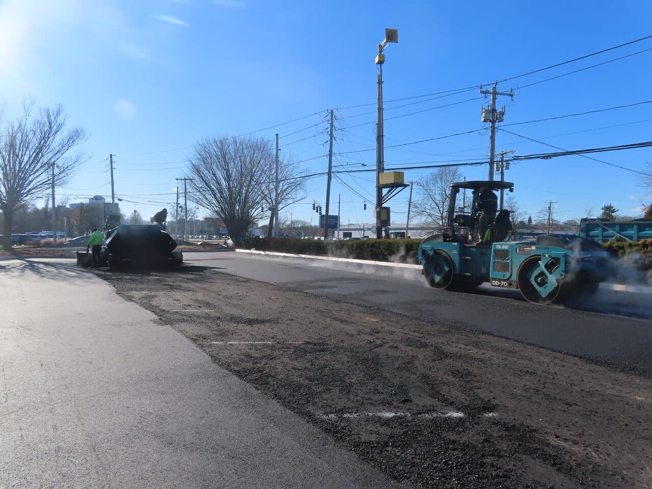 Commercial Parking Lot Paving project in Hartford, CT — paver and roller laying asphalt on roadway