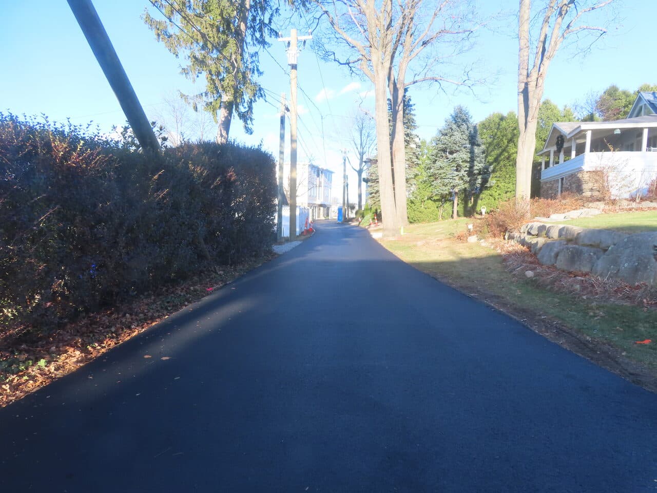 Roadway Paving project in Branford, CT — finished asphalt road between homes