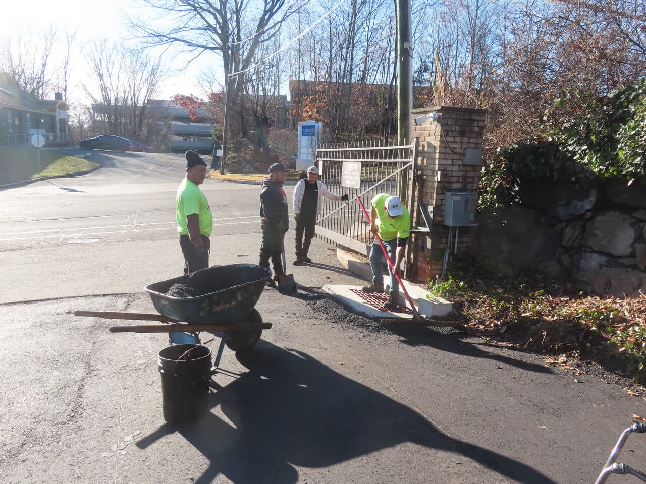 HOA & Condo Roadway Paving project in Stamford, CT — crew patching asphalt at gated entrance