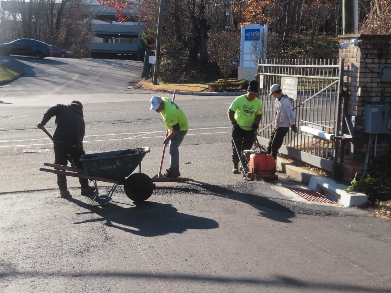 HOA & Condo Roadway Paving project in Stamford, CT — crew spreading asphalt patch at entrance