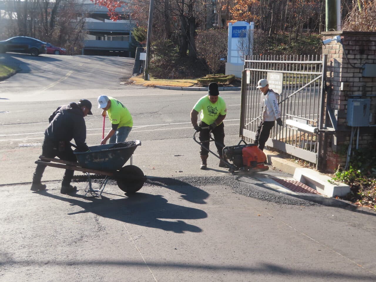 HOA & Condo Roadway Paving project in Stamford, CT — crew using jackhammer near gate