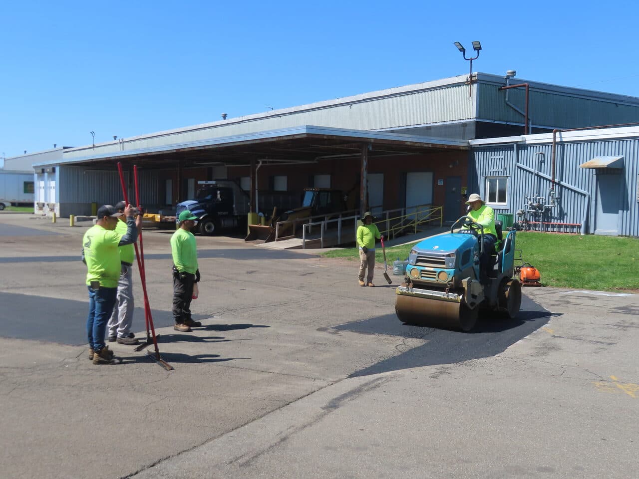 Commercial Parking Lot Repair & Patching project in Northford, CT — paving crew with roller at loading dock