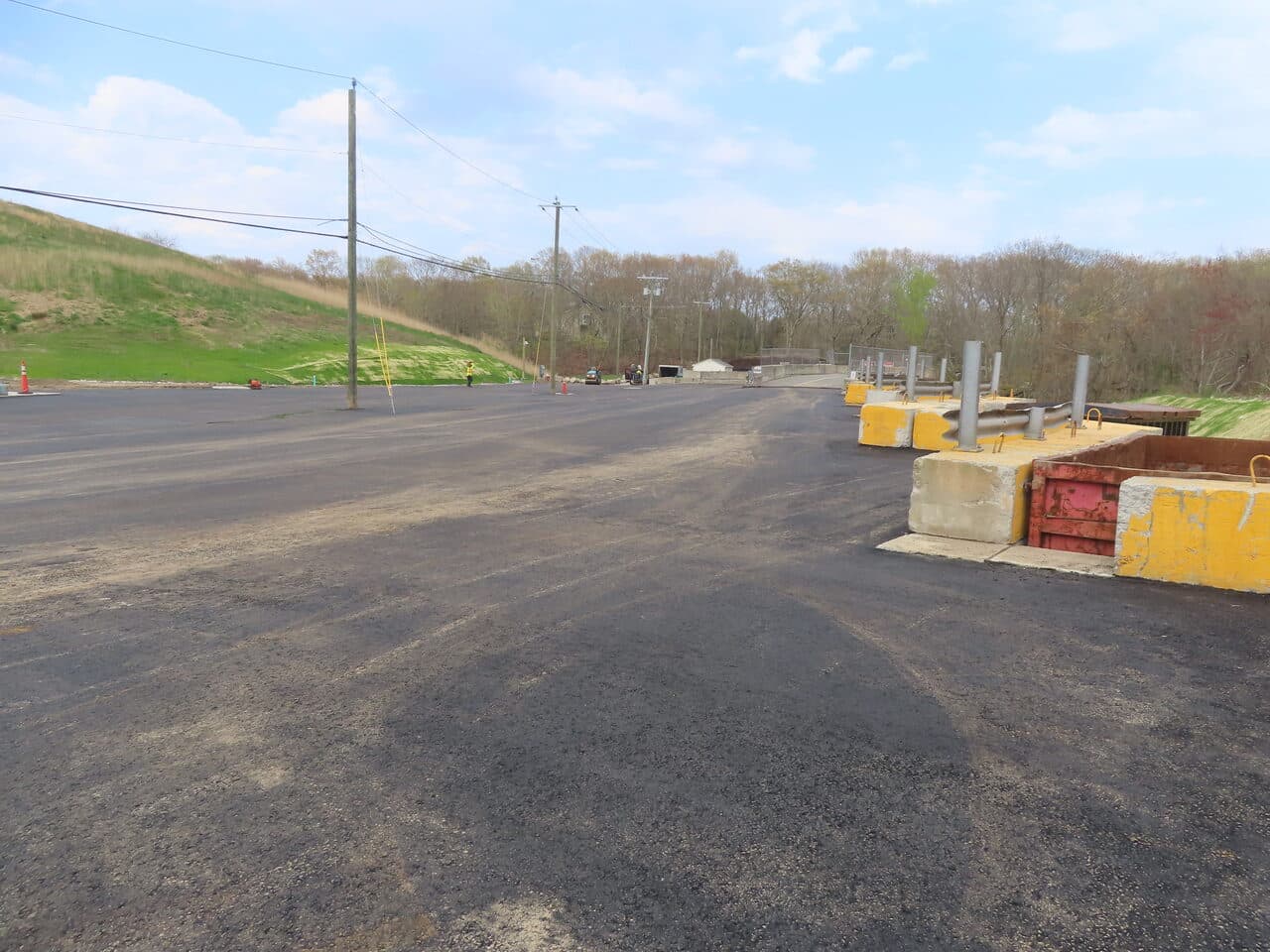 Commercial Parking Lot Paving project in East Lyme, CT — finished asphalt lot with concrete barriers