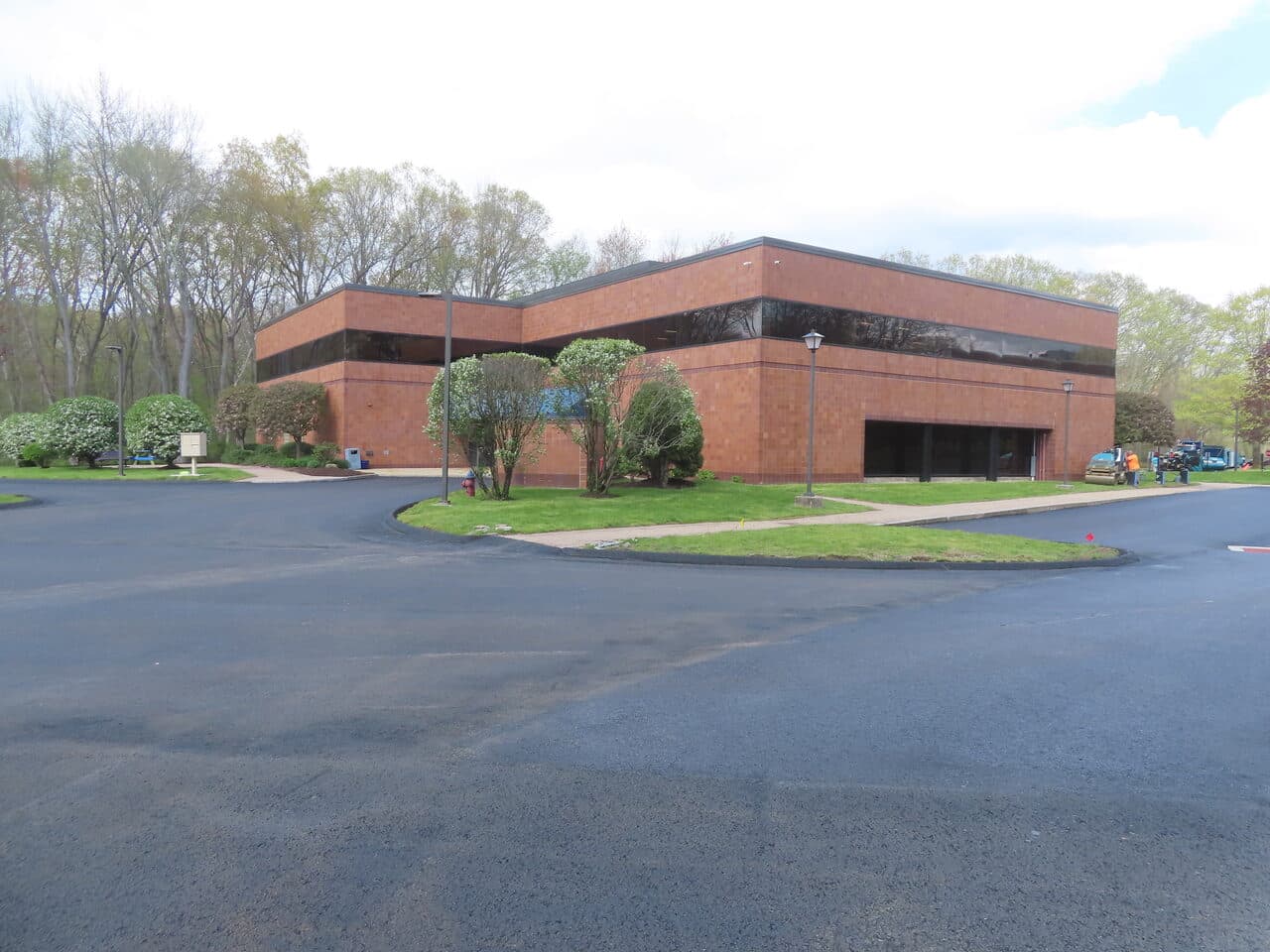 Commercial Sealcoating project in Glastonbury, CT — fresh sealcoated lot by brick building