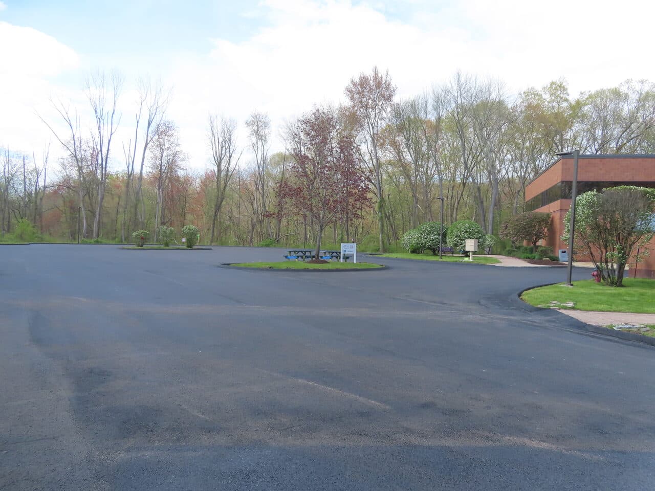 Commercial Sealcoating project in Glastonbury, CT — wide fresh black lot island and building