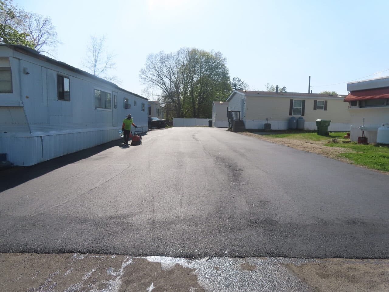 Commercial Parking Lot Paving project in Branford, CT — worker sealing mobile home park road