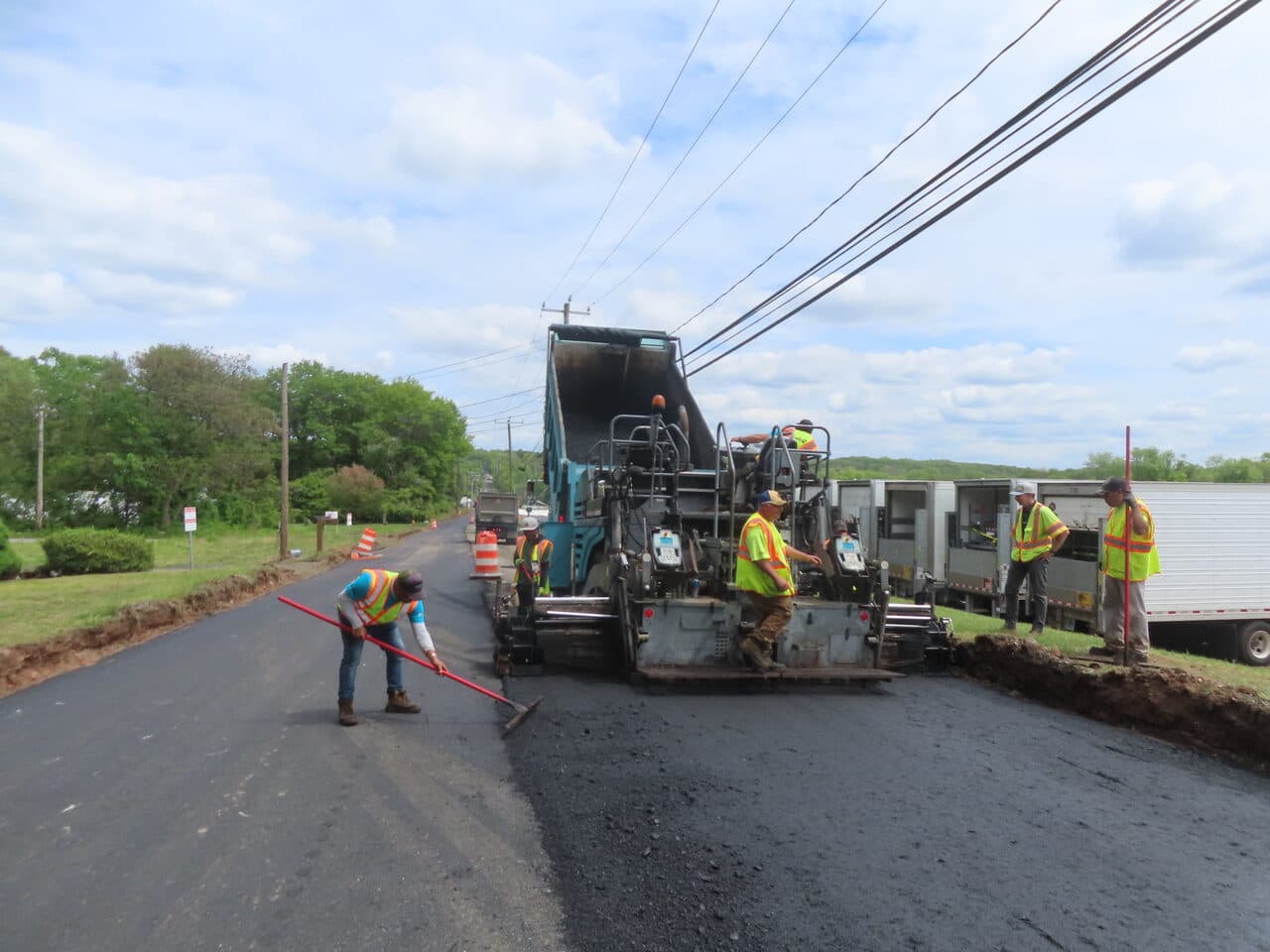 Roadway Paving project in Cheshire, CT — paver crew laying asphalt with rake