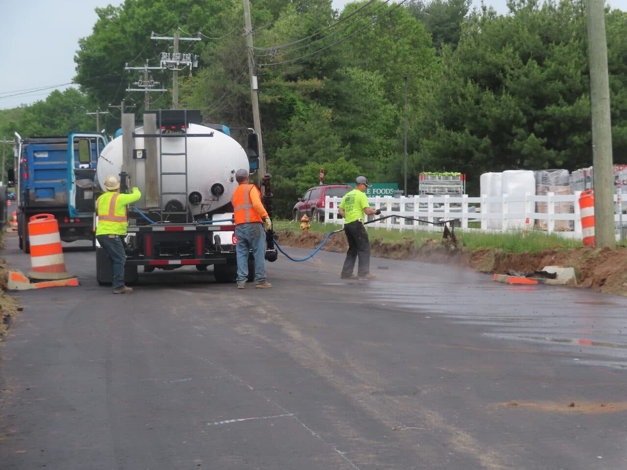 Roadway Paving project in Cheshire, CT — crew tack coat spraying on road
