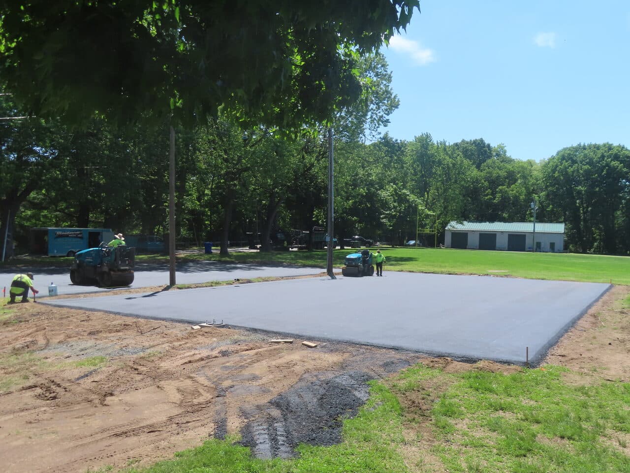 Parking Lot & Athletic Surface Base Paving project in East Hartford, CT — new asphalt lot with rollers