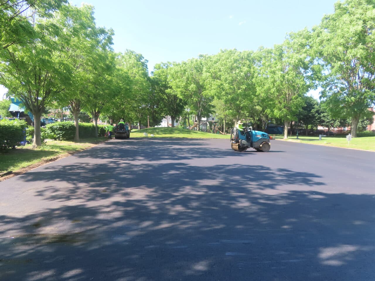Parking Lot & Athletic Surface Base Paving project in East Hartford, CT — new paved road tree-lined